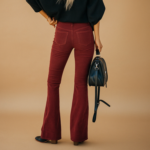 Arabella flared corduroy trousers in burgundy shown full length with a black top and shoulder bag