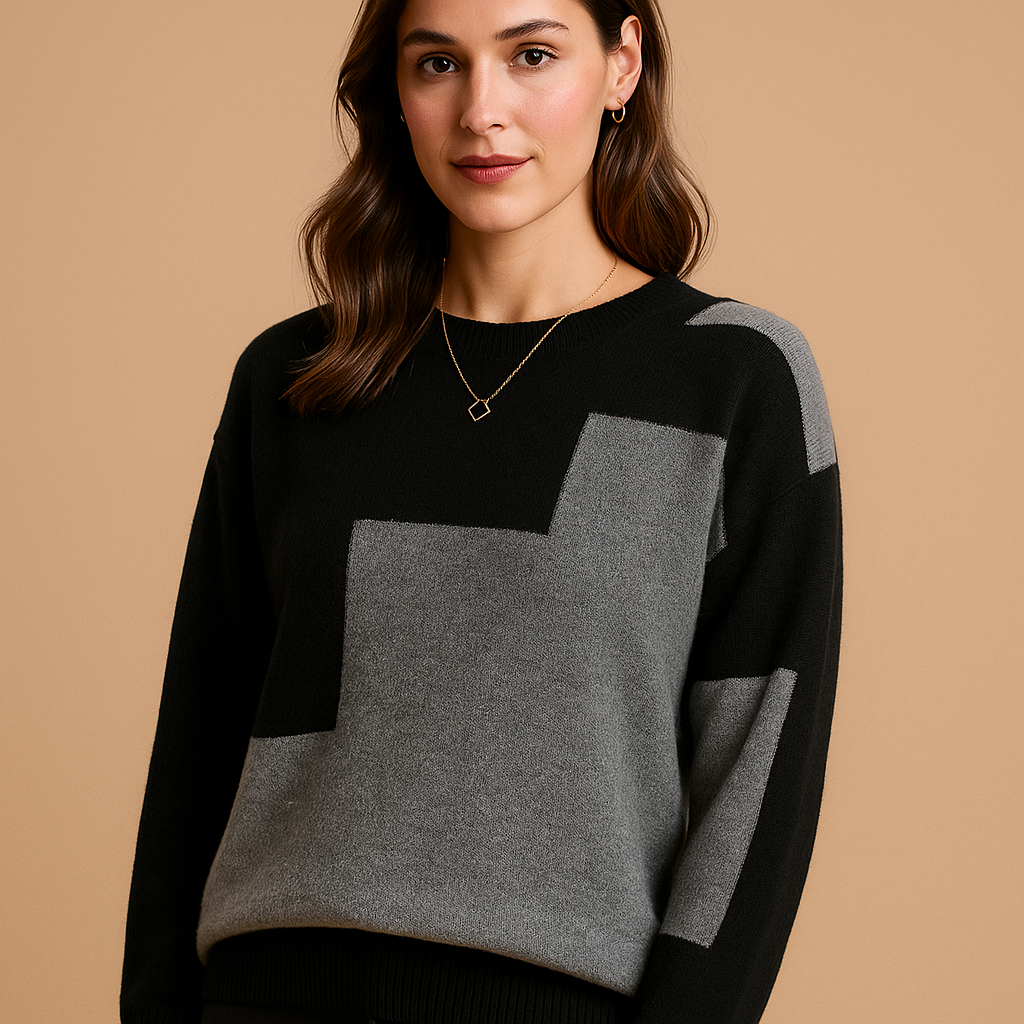 Woman wearing the Astrid loose-fit sweater in black with a grey colour-block panel on the front