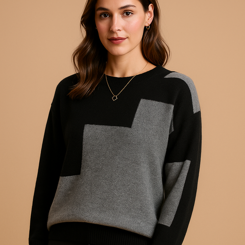 Woman wearing the Astrid loose-fit sweater in black with a grey colour-block panel on the front