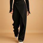 Mabel asymmetric baggy trousers in black with a wide relaxed leg, worn with white trainers