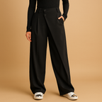 Mabel asymmetric baggy trousers in black shown full length with a black top and white trainers